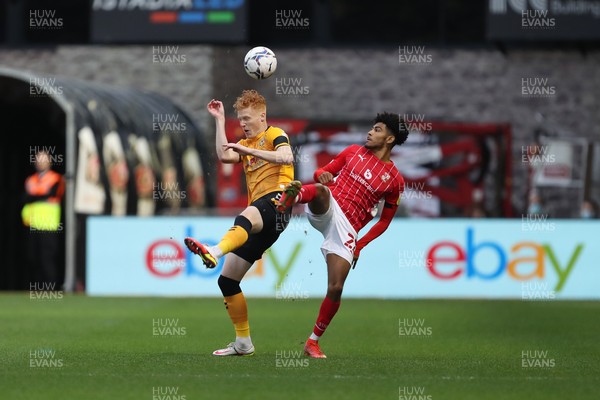 201121 - Newport County v Swindon Town - Sky Bet League 2 - Ryan Haines of Newport County and Kaine Kesler of Swindon Town challenge for the ball