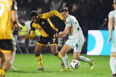 030326 - Newport County v Tranmere Rovers - Sky Bet League 2 - Bobby Kamwa of Newport County is challenged by James Plant of Tranmere