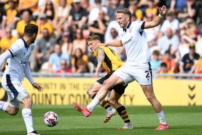 030525 - Newport County v Tranmere Rovers - Sky Bet League 2 - Kai Whitmore of Newport County is challenged by Cameron Norman of Tranmere Rovers