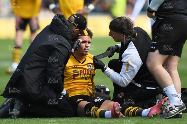 210425 - Newport County v Walsall - Sky Bet League 2 - Josh Martin of Newport County is taken out by Tommy Simkin of Walsall and receives urgent treatment
