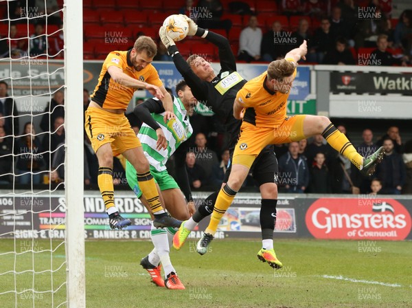 140417 - Newport County v Yeovil Town, Sky Bet League 2 - Yeovil goalkeeper John Maddison claims the ball under pressure from Ryan Bird of Newport County and Mickey Demetriou of Newport County