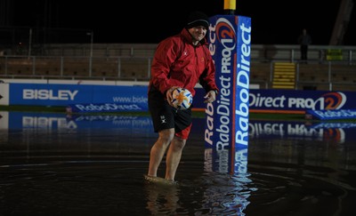 04.11.11 - Newport-Gwent Dragons v Cardiff Blues - RaboDirect PRO12 - Dragons coach Shaun Conner retrieves a ball from the water logged pitch at Rodney Parade. 