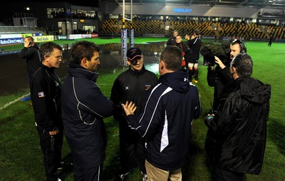 04.11.11 - Newport-Gwent Dragons v Cardiff Blues - RaboDirect PRO12 - Referee Nigel Owens talks Dragons coach Darren Edwards and Cardiff Blues coach Gareth Baber on the water logged pitch at Rodney Parade. 