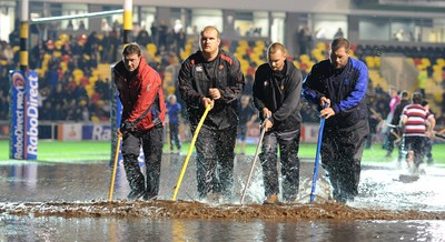 04.11.11 - Newport-Gwent Dragons v Cardiff Blues - RaboDirect PRO12 - Fans and officials try to clear the water logged pitch at Rodney Parade. 