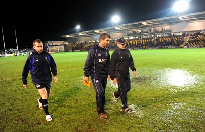 04.11.11 - Newport-Gwent Dragons v Cardiff Blues - RaboDirect PRO12 - Referee Nigel Owens(L) leaves the water logged pitch at Rodney Parade with Dragons coach Darren Edwards and Blues coach Gareth Baber(C) after the game is postponed. 