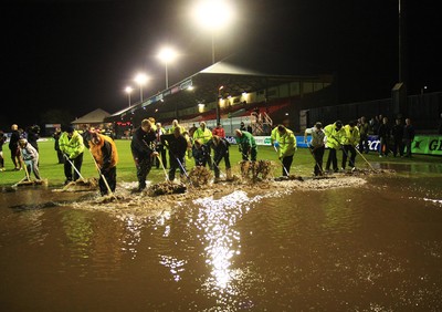 04.11.11 Dragons v Blues - RaboDirect PRO 12 - Ground staff, stewards and ball boys attempt to clear rain water before kick off 