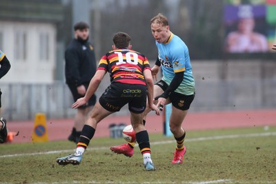 150225 - Newport RFC v Carmarthen Quins - Super Rygbi Cymru (SRC) - David Richards of Newport kicks through under pressure from Ellis Payne of Carmarthen