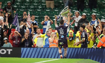 240525 - Northampton Saints v Union Bordeaux-Begles, EPCR Champions Cup Final - Matthieu Jalibert of Union Bordeaux-Begles lifts the trophy as he celebrates with fans