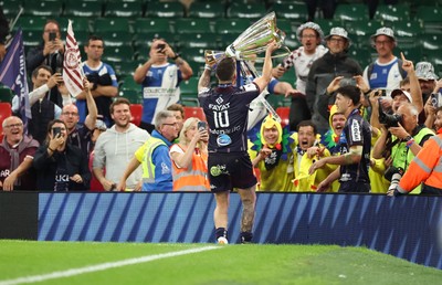 240525 - Northampton Saints v Union Bordeaux-Begles, EPCR Champions Cup Final - Matthieu Jalibert of Union Bordeaux-Begles lifts the trophy as he celebrates with fans