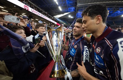 240525 - Northampton Saints v Union Bordeaux-Begles, EPCR Champions Cup Final - Matthieu Jalibert and Louis Bielle-Biarrey of Union Bordeaux-Begles celebrate with the trophy and fans