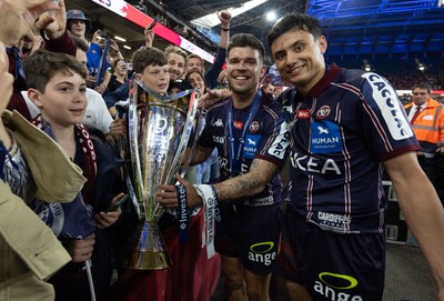240525 - Northampton Saints v Union Bordeaux-Begles, EPCR Champions Cup Final - Matthieu Jalibert and Louis Bielle-Biarrey of Union Bordeaux-Begles celebrate with the trophy and fans