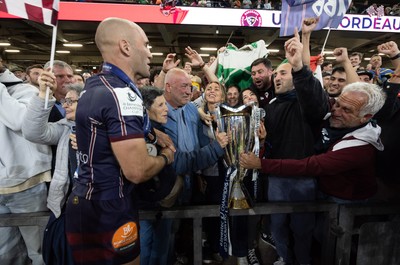 240525 - Northampton Saints v Union Bordeaux-Begles, EPCR Champions Cup Final - Maxime Lucu of Union Bordeaux-Begles celebrates with the trophy and fans