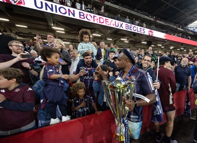 240525 - Northampton Saints v Union Bordeaux-Begles, EPCR Champions Cup Final - Union Bordeaux-Begles players celebrate with the trophy and fans