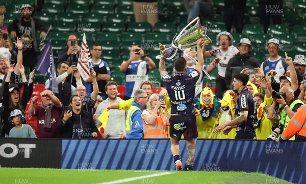 240525 - Northampton Saints v Union Bordeaux-Begles, EPCR Champions Cup Final - Matthieu Jalibert of Union Bordeaux-Begles lifts the trophy as he celebrates with fans