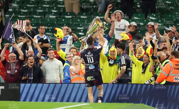 240525 - Northampton Saints v Union Bordeaux-Begles, EPCR Champions Cup Final - Matthieu Jalibert of Union Bordeaux-Begles lifts the trophy as he celebrates with fans