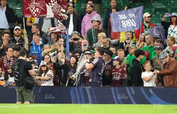 240525 - Northampton Saints v Union Bordeaux-Begles, EPCR Champions Cup Final - Marko Gazzotti of Union Bordeaux-Begles lifts the trophy as he celebrates with fans