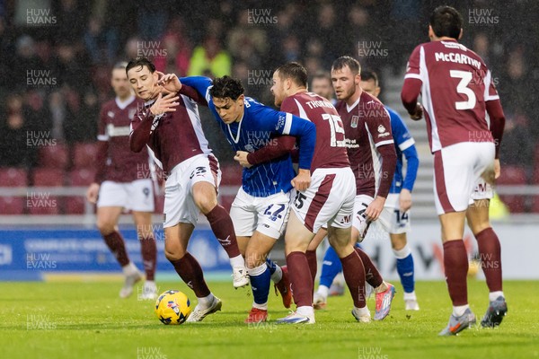 221125 - Northampton Town v Cardiff City - Sky Bet League 1 - Yousef Salech of Cardiff City held by Terry Taylor of Northampton Town and Jordan Thorniley of Northampton Town