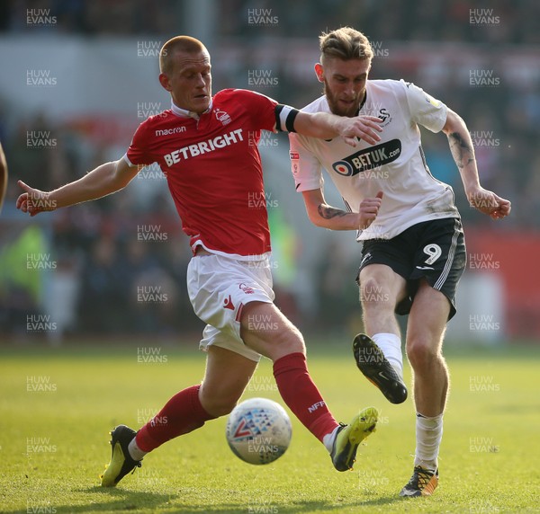 300319 - Nottingham Forest v Swansea City - SkyBet Championship - Oli McBurnie of Swansea City is challenged by Ben Watson of Nottingham Forest