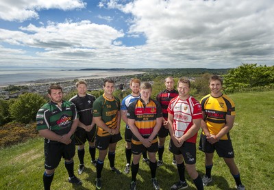 220513 - Ospreys - Pictured with Swansea Bay in the background are Opsreys players LtR: Ryan Bevington in Porthcawl kit, Jonathan Spratt in Neath Athletic kit, Scott Baldwin in Bridgend Athletic kit, Dan Baker in Astradgynlais kit, Dafydd Howells in Abercrave kit, James King in Mold kit, Dan Biggar in Gorseinon kit and Ashley Beck in Skewen kit