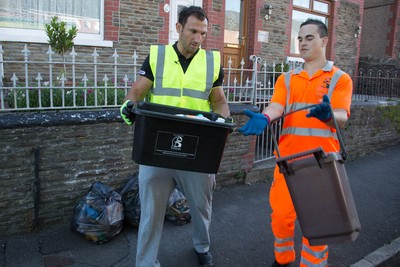 290714 -  Ospreys Joe Bearman helps out on the council's household recycling collection in Maesteg 