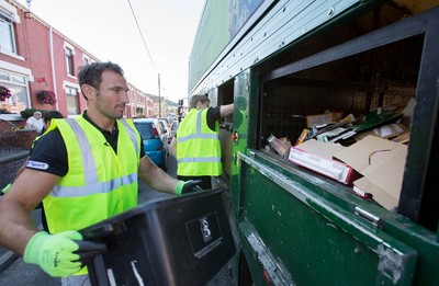 290714 -  Ospreys Joe Bearman helps out on the council's household recycling collection in Maesteg 