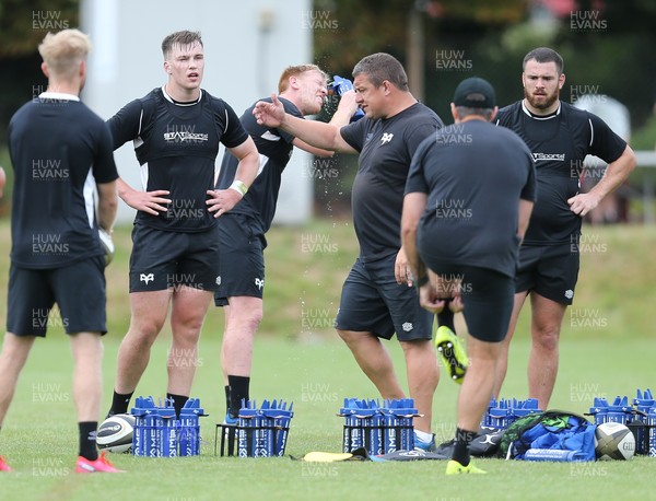 270721 - Ospreys Training session - Head coach Toby Booth talks to the players as Sam Cross cools down during training session