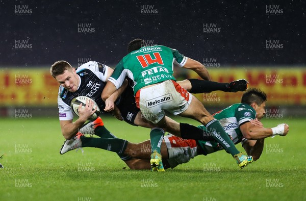 121019 - Ospreys v Benetton Rugby Treviso, Guinness PRO14 - Tom Williams of Ospreys is tackled by Ignacio Brex of Benetton Rugby and Leonardo Sarto of Benetton Rugby