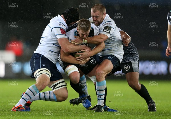 211219 - Ospreys v Cardiff Blues - Guinness PRO14 - Bradley Davies of Ospreys is tackled by James Ratti and Scott Andrews of Cardiff Blues