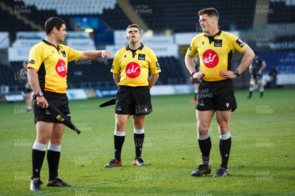 240421 - Ospreys v Cardiff Blues - Guinness PRO14 Rainbow Cup - Referee Sam Grove-White (R) watches the big screen with his assistants