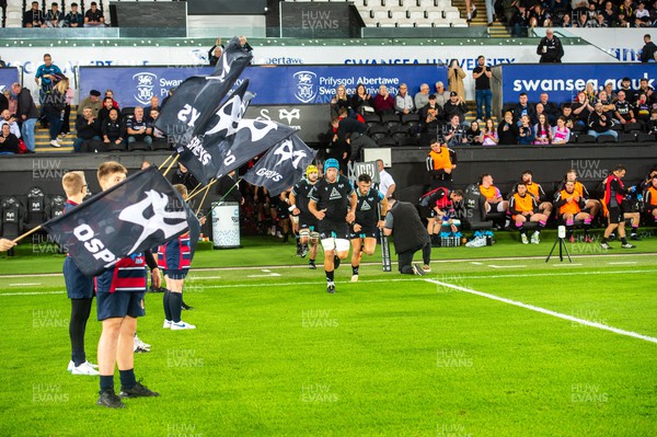 061023 - Ospreys v Cardiff Rugby - Preseason Friendly - Justin Tipuric leads his team out past the flag bearers