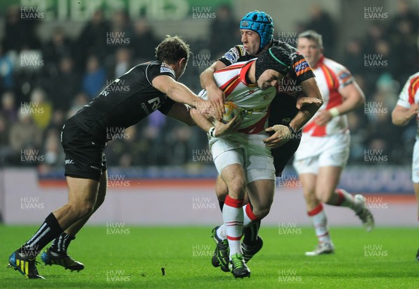 220313 -  Ospreys v Newport-Gwent Dragons - RaboDirect PRO12 -Adam Hughes of Newport-Gwent Dragons is tackled by Ashley Beck and Justin Tipuric of Ospreys 