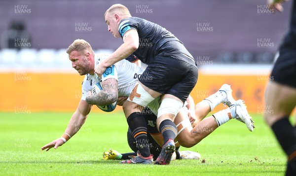 250323 - Ospreys v Dragons - United Rugby Championship - Ross Moriarty of Dragons is tackled by Morgan Morris and Huw Sutton of Ospreys