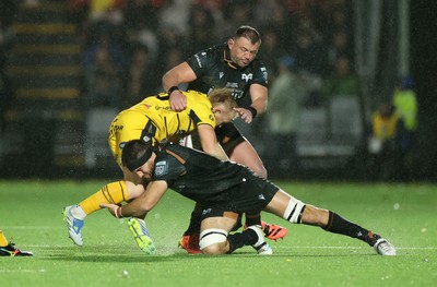 241026 - Ospreys v Dragons - United Rugby Championship - Tinus de Beer of Dragons is tackled by Ryan Smith and Sam Parry of Ospreys 