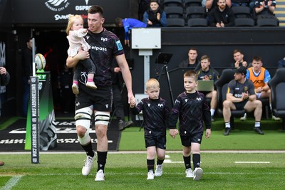 260425 - Ospreys v Dragons RFC - United Rugby Championship - Adam Beard of Ospreys walks out with his family at the start of the match