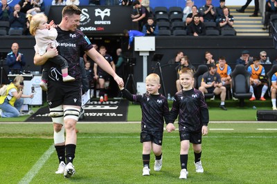260425 - Ospreys v Dragons RFC - United Rugby Championship - Adam Beard of Ospreys walks out with his family at the start of the match