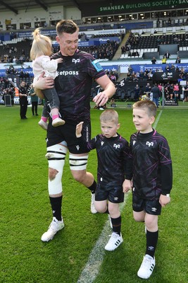 260425 - Ospreys v Dragons RFC - United Rugby Championship - Adam Beard of Ospreys walks out with his family at the start of the match