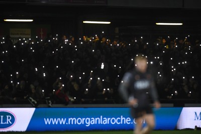 310126 - Ospreys v Dragons RFC - United Rugby Championship - Ospreys fans shine their phone lights in protest in the 11th minute