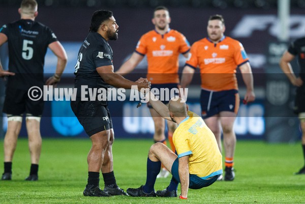 290122 - Ospreys v Edinburgh - United Rugby Championship - Elvis Taione of Ospreys helps Referee Andrea Piardi up off the floor after he was knocked over