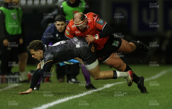 230126 - Ospreys v Emirates Lions - United Rugby Championship - Kieran Hardy of Ospreys is tackled by PJ Botha of Lions 