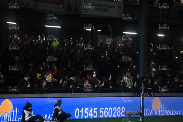 230126 - Ospreys v Emirates Lions - United Rugby Championship - Ospreys fans shine their phone lights in protest in the 11th minute