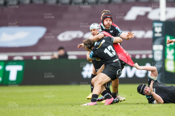 300324 - Ospreys v Emirates Lions - United Rugby Championship - \Edwill van der Merwe of Lions is tackled by Evardi Boshoff and Morgan Morris of Ospreys