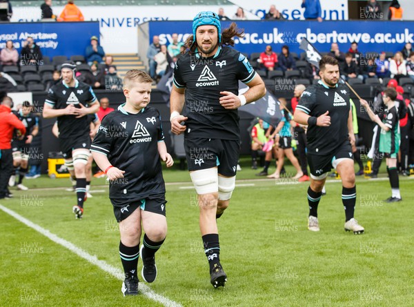300324 - Ospreys v Emirates Lions - United Rugby Championship - Justin Tipuric of Ospreys leads the team out with the mascot
