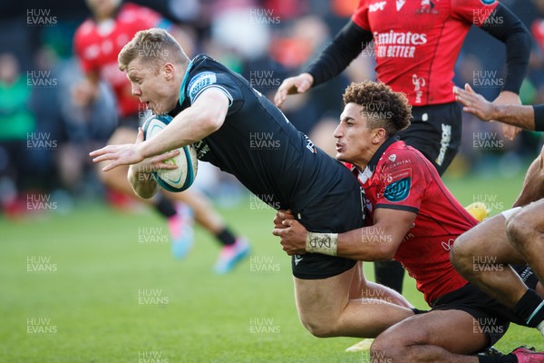 300324 - Ospreys v Emirates Lions - United Rugby Championship - Keiran Williams of Ospreys is tackled by Jordan Hendrikse of Lions but goes over for a try
