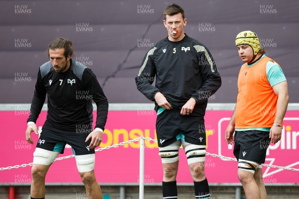 300324 - Ospreys v Emirates Lions - United Rugby Championship - Justin Tipuric, Adam Beard and Harri Deaves of Ospreys during the warm up