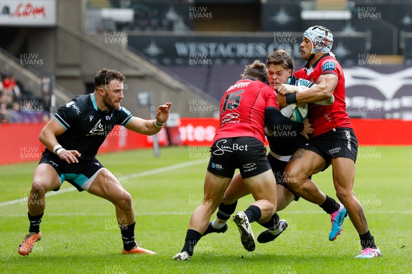 300324 - Ospreys v Emirates Lions - United Rugby Championship - Jack Walsh of Ospreys tackled by Quan Horn of Emirates Lions