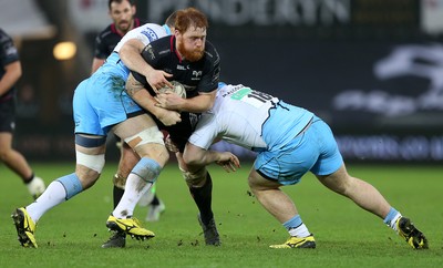 310116 - Ospreys v Glasgow - Guinness PRO12 - Dan Baker of Ospreys is tackled by James Eddie and D'arcy Rae of Glasgow