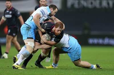 310116 - Ospreys v Glasgow - Guinness PRO12 - Dan Baker of Ospreys is tackled by James Eddie and D'arcy Rae of Glasgow