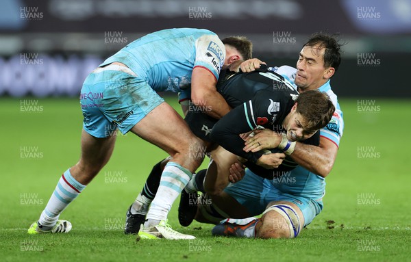 111123 - Ospreys v Glasgow Warriors - United Rugby Championship - Jack Walsh of Ospreys is tackled by Ollie Smith and Henco Venter of Glasgow 