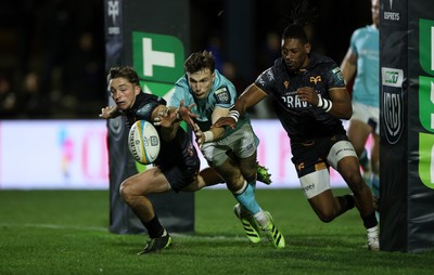 181025 - Ospreys v Glasgow Warriors - United Rugby Championship - Jamie Dobie of Glasgow dives for the ball alongside Dan Edwards and Dan Kasende of Ospreys 