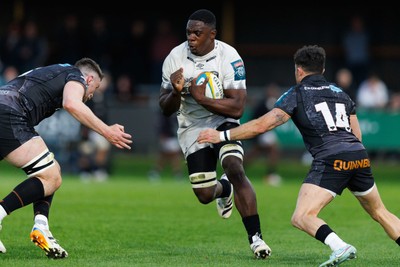 180426 - Ospreys v Hollywoodbets Sharks - United Rugby Championship - Manu Tshituka of Sharks is tackled by James Ratti and Luke Morgan of Ospreys